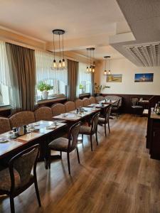 a restaurant with tables and chairs in a room at Hotel Pension Loose in Borkum