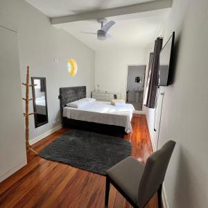 a bedroom with a bed and a chair in it at Pousada Madalena in Sao Paulo
