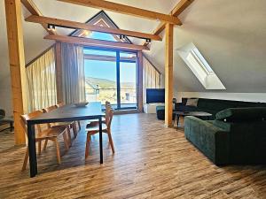 a living room with a dining table and a couch at Apartmán Nad Údolím Šumava in Prachatice