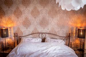 ein Schlafzimmer mit einem Bett und zwei Wandlampen in der Unterkunft The White Walker*** in Libin