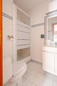 a white bathroom with a toilet and a sink at Casa da Joana in Mirandela