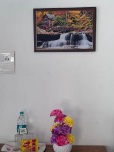 a picture of a waterfall and a vase with flowers at Hornbill inn in Cochin
