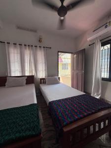 a bedroom with two beds and a window at Hornbill inn in Cochin