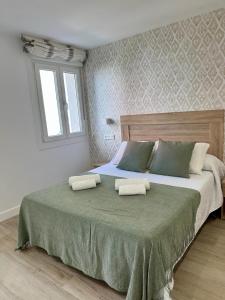 Un dormitorio con una cama grande con dos almohadas. en Fogar de Fefiñáns, en Cambados