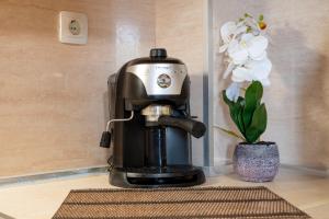 eine Kaffeemaschine auf einem Tisch neben einer Blume in der Unterkunft Villa МareMaria in Nea Kallikratia