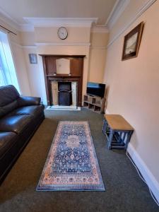 a living room with a couch and a fireplace at Carlcroft Cottage in Alwinton