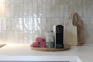 a kitchen counter with a coffee maker and roses on a tray at Vakantiewoning Molenveld in Dilsen-Stokkem