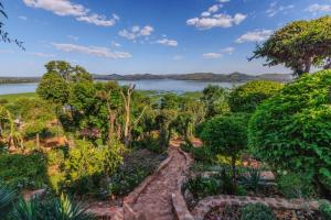 a garden with a view of a lake at Romantic Cosy fire-place at Enso Botanico Boutique Villa, Kosmos in Hartbeespoort