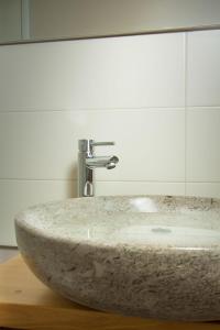 marmurowa umywalka w łazience z lustrem w obiekcie Apartment Dandelion w mieście Branik