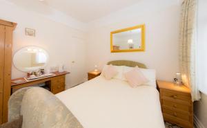a bedroom with a white bed and a mirror at Shoreline Accommodation in Bournemouth