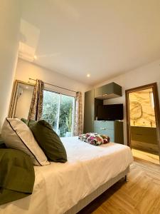 Un dormitorio con una cama con almohadas verdes y una ventana. en CANNES Maison Design "DOLCE VITA", en Cannes