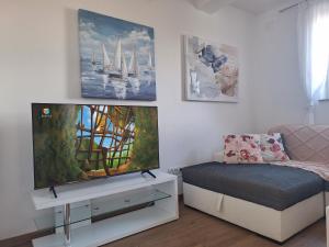 a living room with a flat screen tv and a couch at Villa Tea in Murter