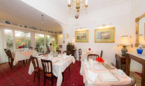 a dining room with white tables and chairs at Shoreline Accommodation in Bournemouth