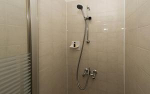 a shower with a shower head in a bathroom at Shoreline Accommodation in Bournemouth