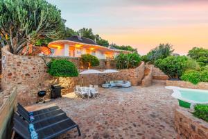 a house with a stone wall and a pool at Enso Botanico Boutique Villa, Kosmos in Hartbeespoort