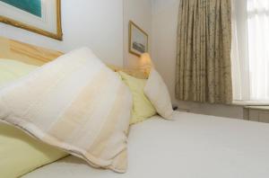 a bedroom with a bed with two pillows at Shoreline Accommodation in Bournemouth