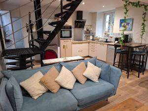 a living room with a blue couch with pillows at Le petit saint Germain in Digosville