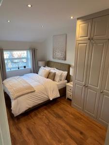 Night Owl Cottage في Rainford: غرفة نوم بها سرير بملاءات بيضاء ونافذة