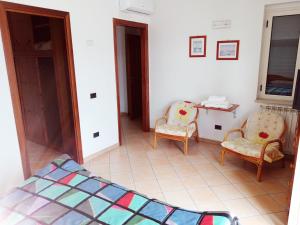 Zimmer mit 2 Stühlen, einem Tisch und einem Spiegel in der Unterkunft Torre Ancinale in Soverato Marina
