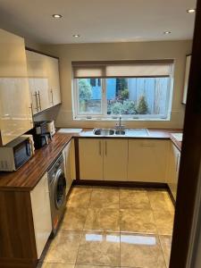 Night Owl Cottage في Rainford: مطبخ مع حوض وغسالة ملابس +18 صورة