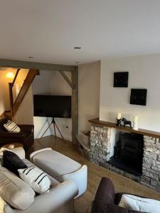 Night Owl Cottage في Rainford: غرفة معيشة مع أريكة ومدفأة