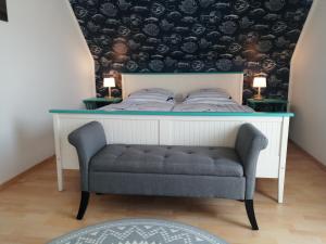 a bedroom with a bed and a blue chair at Ferienwohnungen am Waldbad Zwenkau in Zwenkau