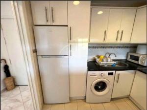 a kitchen with a refrigerator and a washing machine at Alhamar Cabopino Living Apartment in Málaga