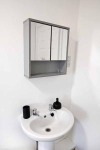 a bathroom with a white sink and a mirror at 2bed Cowgate next Newcastle Golf Club Free Parking in Kenton +43 photos