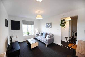 a living room with a couch and a tv at 2bed Cowgate next Newcastle Golf Club Free Parking in Kenton