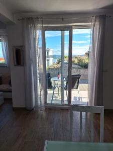a room with a sliding glass door with a table and a balcony at Villa Tea in Murter