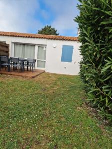 a patio with a table and chairs in a yard at la belle cascade 2 in Dolus-d'Oléron
