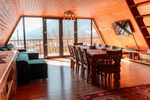 a large dining room with a table and chairs at Catunul Lacului Fermecat in Pleşi