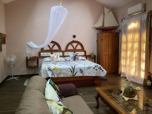 a bedroom with a bed and a couch and a table at cabin Claro luna orchard swimming pool 70mbps wifi in La Esperanza +14 photos