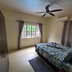 a bedroom with a bed and a ceiling fan at Six Senses in Marloth Park