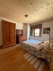 a bedroom with a bed and a wooden ceiling at La Ciasa Dell'Emigrante in Cibiana
