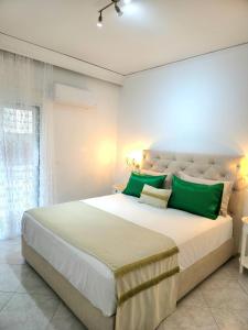 a bedroom with a large bed with green pillows at City Center Luxury Spacious apt A&M II in Rhodes Town