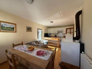 a living room with a table and a kitchen at La Ciasa Dell'Emigrante in Cibiana