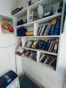 a book shelf filled with lots of books at Papa Maddy Hostel & Homestay in Tājganj