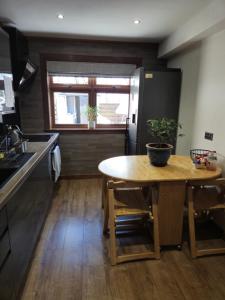 a kitchen with a wooden table with a potted plant on it at Self-catering extended family home in Edinburgh +1 photo