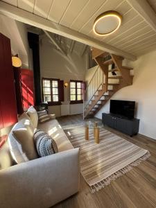 a living room with a couch and a staircase at Antalki Experience Apartments in Papingo