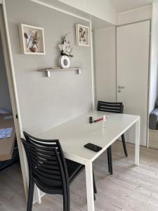 塞里尼昂Mobile home 4-6 places camping les sables du midi的客房内的白色桌椅