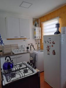 a kitchen with a stove and a white refrigerator at Depto Ensueño Patagonia in Puerto Natales