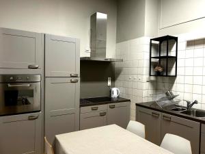 a kitchen with white appliances and a table in it at La Citadine in Neufchâteau