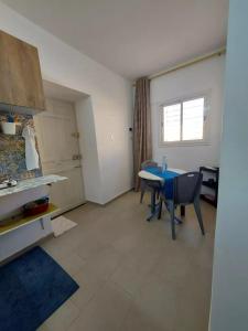 a kitchen and dining room with a table and chairs at Charming waterfront studio in Sidi el Moujahed