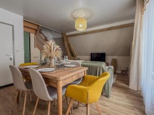 a dining room with a wooden table and yellow chairs at Beau duplex quartier historique in Chartres