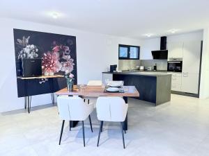 eine Küche mit einem Holztisch und weißen Stühlen in der Unterkunft Teuto Loft in Hörstel + 13 Fotos