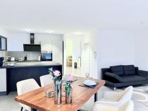 eine Küche und ein Wohnzimmer mit einem Holztisch und Stühlen in der Unterkunft Teuto Loft in Hörstel