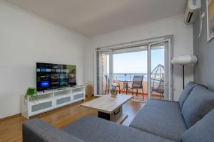 Una sala de estar con un sofá, un televisor y una mesa. en Azzurro Apartment in Utjeha, en Utjeha