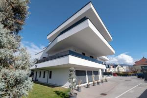 a white building with a large arrow on it at Amaria Downtown Aparthotel Villach in Villach