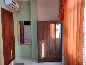 a room with a wooden cabinet and a mirror at Suit semi amoblada in Machala